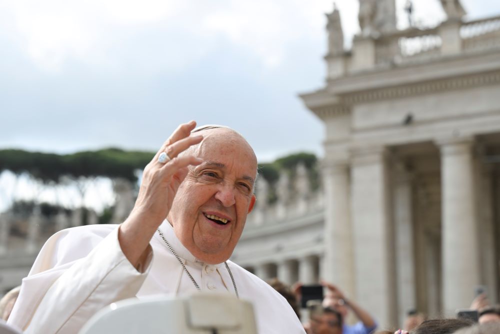 Pope Francis waves to visitors in St. Peter's Square while riding the popemobile before his general audience at the Vatican May 22.